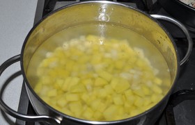 На конфорку ставим кастрюлю с водой для супа, в которую закладываем нарезанный картофель, пусть варится потихоньку.