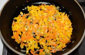 Вторую половину лука слегка обжариваем на огне не больше среднего с растительным маслом, через 5-7 минут кладем нарезанный сладкий перец и морковь. Тушим 5-6 минут, солим и перчим, выкладываем, чтобы начинка остыла.