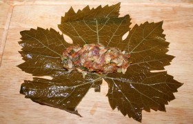 Листья винограда выкладываем в дуршлаг, чтобы сошла вода. Каждый листик располагаем на доске блестящей стороной вниз, кладем 2-3 ч. ложки начинки