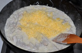 Сметана вскипела – засыпаем сыр, перемешиваем. Он быстро расплавляется – а мы спустя 2-3 минутки выключаем огонь, оставляем мясо в соусе в накрытой крышкой сковороде на 6-8 минут.