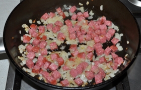 Добавляем мелкие кубики колбасы, 3-4 минуты слегка поджариваем, перемешивая. Одновременно ставим воду для варки пасты. Не обязательно фузилли, но достаточно крупной  пасты , которая хорошо вбирает соус.