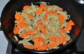 На той же сковороде, уменьшив огонь до среднего, обжариваем ( пассеруем ) полукольца лука 5-7 минут. Засыпаем тонко нарезанную морковь, продолжаем обжаривать еще 3-4 минуты. 