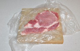 Берем пакет, кладем мясо и  отбиваем  с обеих сторон до толщины 8-10 мм. Если полоска сала где-то стягивает мясо - рассекаем ее.