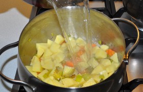 Кладем нарезанную картошку и заливаем горячим бульоном. Без готового бульона – крошим в кастрюлю кубики и заливаем кипящей водой. Под крышкой варим при небольшом кипении 10-15 минут, до готовности картофеля.
