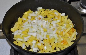 Добавляем лук, немного снижаем огонь, жарим картофель с луком до готовности еще 10-12 минут, часто переворачивая. Попутно солим и перчим.