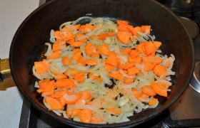 Пока разогревается на среднем огне масло, шинкуем полукольцами луковицы и нарезаем кружками морковь.  Пассеруем  все это в сковороде 6-8 минут. 