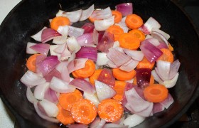 Ставим две сковороды, наливаем понемногу растительного масла,  перекаливаем  на сильном огне. В меньшую сковородку загружаем морковь, лук, перемешиваем, убираем огонь до среднего и, не забывая по мере необходимости помешивать, оставляем на 9-12 минут, до мягкости лука.