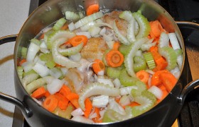 Добавляем нарезанные толстыми кружками моркови, полукольца лука и  нарубленный сельдерей. После закипания оставляем  тушиться  (под крышкой) 35-40 минут на небольшом огне. 2-3 раза перемешиваем овощи и курицу. 