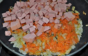 Нарезаем мелко репчатый лук, трем морковь, колбасу режем небольшими кубиками. Лук и морковь обжариваем на среднем огне на сковородке с растительным маслом, 5-6 минут, добавляем колбасу, обжариваем 3-5 минут.