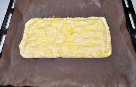 Накрываем другой половиной теста и соединяем края пирога. Мы сделали это приемом  «веревочка» . Смазываем яйцом, которое взбиваем вилкой. Сверху наносим проколы, чтобы тесто не вздувалось. Выпекаем в духовке 20-22 минуты.
