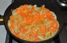 Добавляем натертую морковь, помешиваем и обжариваем 3-5 минут.