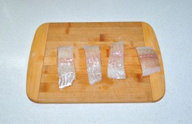 Замороженному рыбному филе даем время стать мягким. Промываем (как и свежее)  – и бумажными полотенцами отжимаем воду. Нарезаем филе поперек полосками по 30-35 мм шириной.