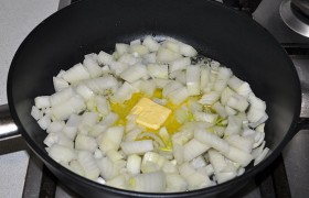 Ставим сковороду с маслом, даем ему растопиться, засыпаем нарезанный кубиком лук. Помешивая, обжариваем на небольшом огне 5-7 минут.