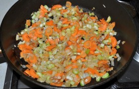 Мелко шинкуем лук, морковь и сельдерей, пассеруем овощи 10-12 минут, пока лук не станет прозрачным, а морковь – мягкой.  Все это время часто помешиваем.