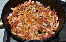 Добавляем мясопродукты в сковороду с луком, обжариваем 3-4 минуты.