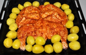 Куриную тушку кладем на середину противня, вокруг раскладываем картофель. При 200° в духовке курица запекается до аппетитного румянца за 45-55 минут.