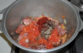 Кладем также томатную пасту, часть приправ, вливаем примерно полстакана горячей воды. 