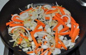 Переменив огонь на средний, добавляем еще немного масла, засыпаем лук с сельдереем и морковью, 10-12 минут томим, помешивая, 