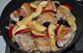 Возвращаем кусочки курицы в сковороду, выкладываем яблоки и чернослив, заливаем херес, добавляем огня для быстрого закипания.