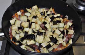 Закладываем кубики следующего овоща – баклажана, смешиваем с луком, морковкой и мясом.