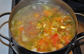 Овощи (выбросив чеснок) перекладываем в суп, в котором уже почти сварилась картошка. Бросаем лавровый лист, перец, солим. Закипевший суп накрываем, переводим огонь конфорки на слабый. Довариваем суп 5-6 минут. И даем ему после выключения настояться 8-10 минут. Удаляем лавровый лист, горошки перца – и подаем со сметаной или йогуртом.