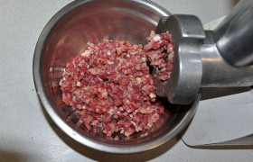 Ставим на мясорубку нож с мелкими отверстиями и дважды измельчаем кусочки желудков вместе с луком.