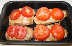 Вымытые и обсушенные помидоры нарезаем толстыми ломтиками - 18-20 мм. Накрываем этими ломтиками куски курицы и отправляем форму или противень в разогретую духовку на 25-30 минут.