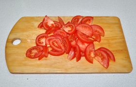 Нарезаем дольками помидоры.