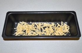 Форму слегка смазываем маслом, дно засыпаем половиной тертого сыра.