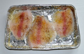 Включив духовку на гриль, промываем и просушиваем филе рыбы. Посыпаем перцем и солью и выкладываем в форму (на противень), сначала смазав дно растительным маслом.