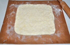 Прямо на коврике для выпечки раскатываем наше тесто в пласт толщиной примерно 9-10 мм.