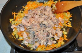В большой сковороде, разогретой с маслом, на среднем огне  пассеруем  7-8 минут нашинкованный средним кубиком лук и натертую морковку. Добавляем вынутую из банок и слегка размятую рыбу, у нас это – горбуша. Посыпаем Итальянскими (или Прованскими) травами, перцем, слегка солим, перемешиваем, выключаем огонь.