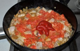 В ту же сковороду кладем измельченные томаты и томатную пасту.