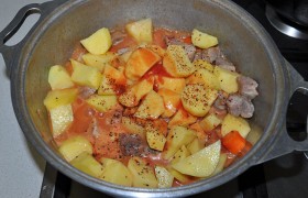 Кладем нарезанный картофель, вливаем томатный сок, посыпаем сахаром, бросаем лавровый лист. И снова ставим тушиться на 15 минут.