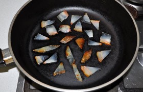 Для соуса копченое сало нарезаем тонкими мелкими ломтиками и вытапливаем из них жир, поставив сковородку на средний огонь.