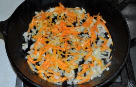 Пока варятся рис и яйца, чистим лук и морковь. Лук мелко шинкуем, морковь натираем. Распускаем в сковороде 2 ст. ложки сливочного масла, выкладываем лук и морковь, на несильном огне обжариваем до прозрачности лука, 10-12 минут. Есть время помыть и нарезать мелко помидор.