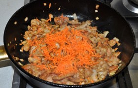 Добавляем тертую морковь и снова обжариваем и помешиваем 2-3 минуты.