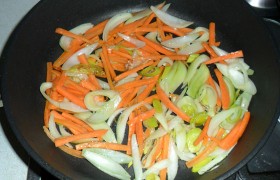 Добавив и накалив немного масла, на том же сильном огне 2-4 минуты, все так же работая лопаткой, обжариваем лук с морковью – 