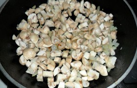 Пока в сковороде на среднем огне 7-8 минут томится шинкованный лук, очищенные шампиньоны нарезаем кусочками. Вместе с луком обжариваем до испарения жидкости и готовности грибов – 5-6 минут. Заправляем перцем и солью.
