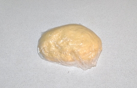 Взбиваем вилкой яйца, добавляем масла, соли. Замешиваем тесто, оставив часть муки в стороне. Ее подсыпаем по мере необходимости, когда мнем тесто. Плотное тесто заворачиваем на 15-20 минут в пленку.