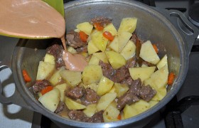 Теперь кладем картофель. Сметану, томатную пасту, сахар и муку смешиваем, разводим водой и вливаем в кастрюлю.