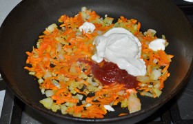 Вторую луковицу и морковь тоже натираем,  пассеруем  на масле 6-7 минут. Добавляем соль и перец, томатную пасту и сметану, вливаем кипяток, размешиваем. 