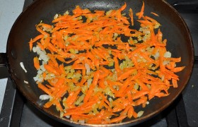 На сковороду, разогретую с маслом на среднем огне, выкладываем тертую морковь и порубленный мелко лук. Периодически перемешивая, пассеруем овощи 8-10 минут, до мягкости моркови. 