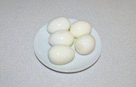 Яйца, на  варку  которых уйдут минуты, быстро охлаждаем, чистим. Делим пополам вдоль и вынимаем желтки. Чтобы вошло больше начинки, можем удалить немного белка в середине.