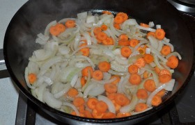 Переводим огонь на средний, 8-10 минут  пассеруем  шинкованные морковь и лук, изредка помешивая. 