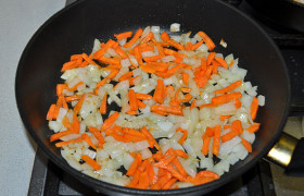 Нашинкованный лук и нарезанную морковь обжариваем 7-9 минут в отдельной сковороде в масле.