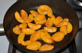 Даем сковороде разогреться на огне немного выше среднего, кладем сливочное масло, нарезанные абрикосы без косточек, обжариваем, добавив мед и цедру, 2-3 минуты.