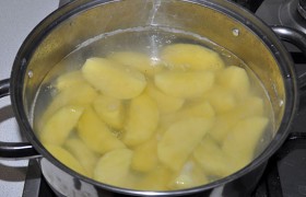 Чистим картофель, крупно нарезаем дольками, заливаем кипятком и варим после закипания 4-5 минут. Из кастрюли сливаем воду, полуготовый картофель приправляем перцем, солью и немного растительным маслом.