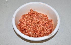 В миску с фаршем наливаем 3-4 столовые ложки приготовленного соуса, добавляем перец и соль, всё вместе вымешиваем до полной однородности. Фарш не должен быть очень плотным.