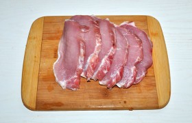 Кусок мяса промываем, поверхность обсушиваем, нарезаем нетолстыми – 10-12 мм – ломтями. Полоски сала на них рассекаем в 2-3 местах (иначе они стянут мясо при жарке).